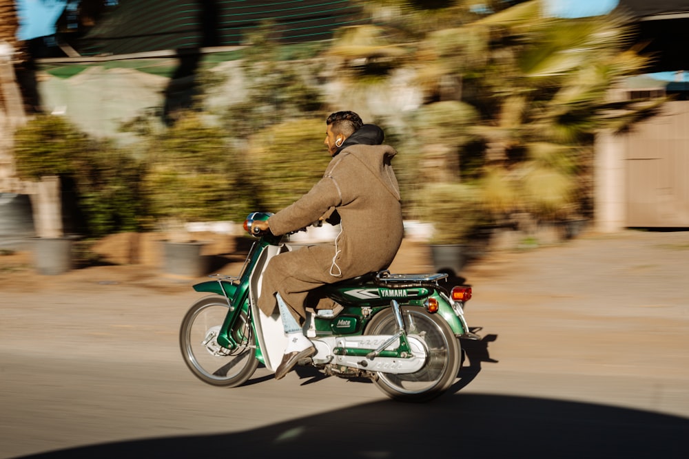 man in brown jacket riding green motorcycle during daytime