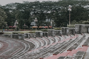 Outdoor amphitheater with people enjoying live music and social gatherings in a garden setting.