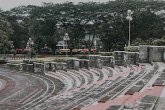 Outdoor amphitheater with people enjoying live music and social gatherings in a garden setting.