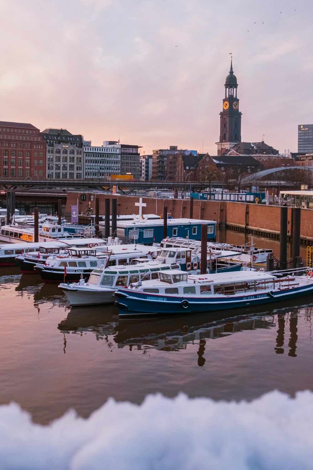 white and blue boat on water near city buildings during daytime