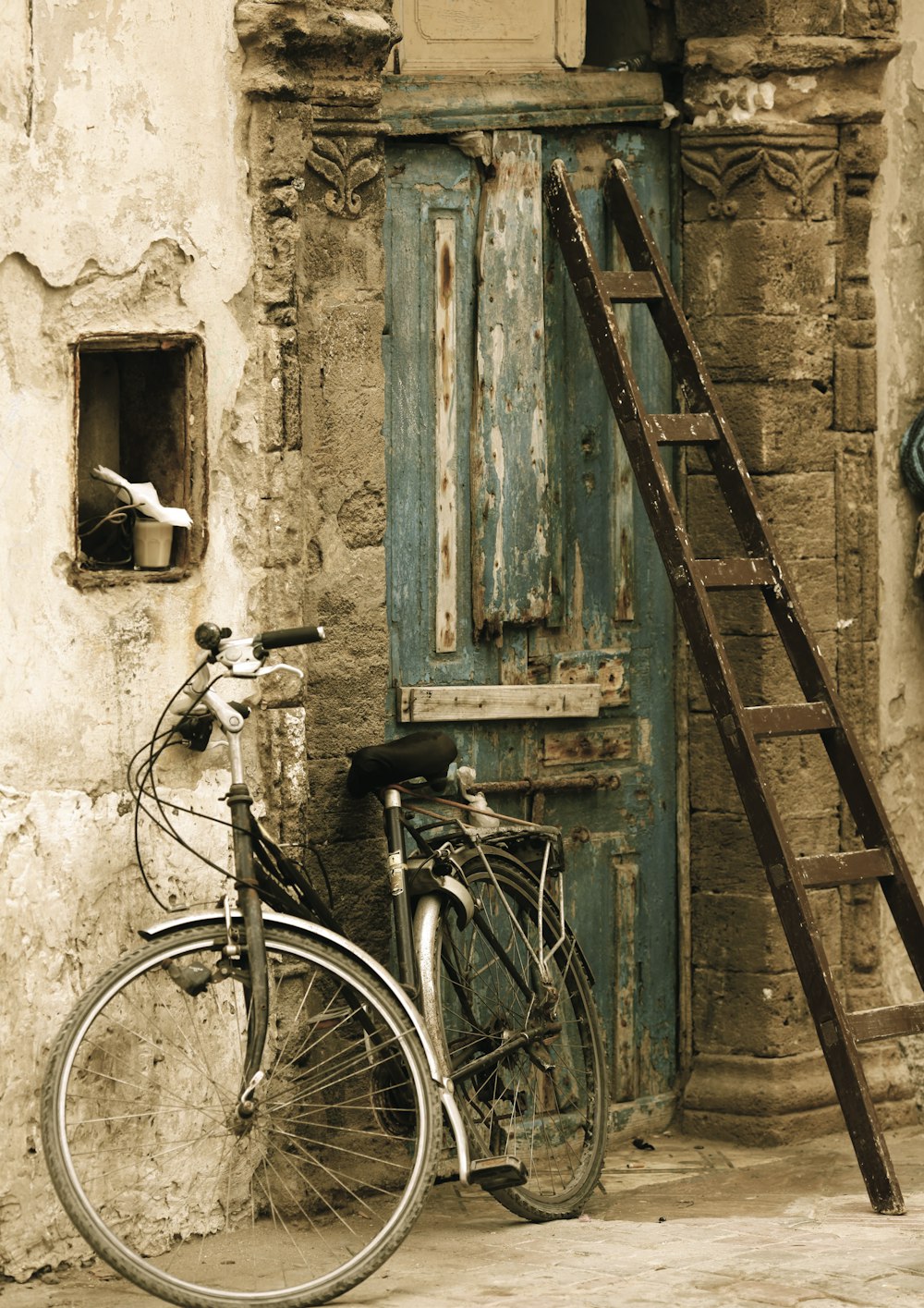 bicicleta preta da cidade apoiada na porta de madeira marrom