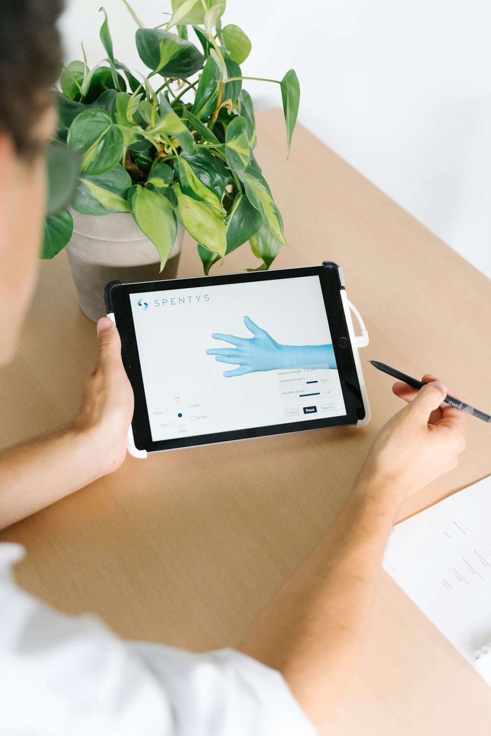 person holding black ipad on brown wooden table