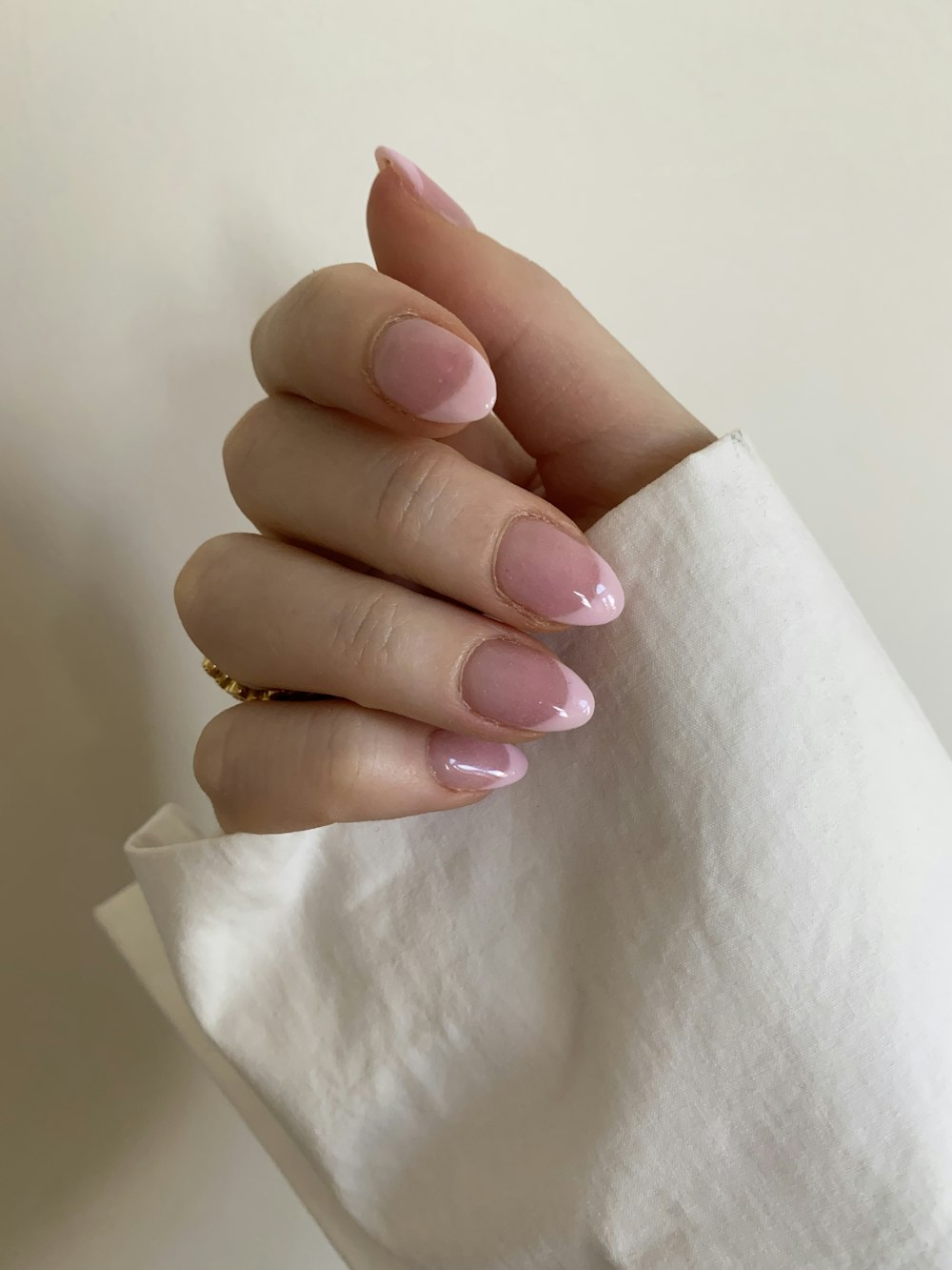 persona con manicura rosa sobre textil blanco