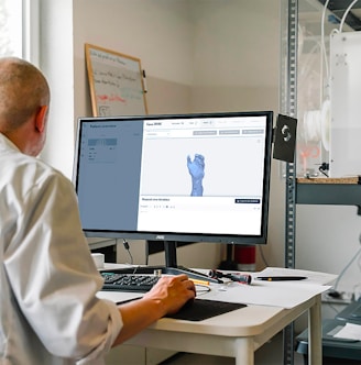 man in white dress shirt sitting in front of computer