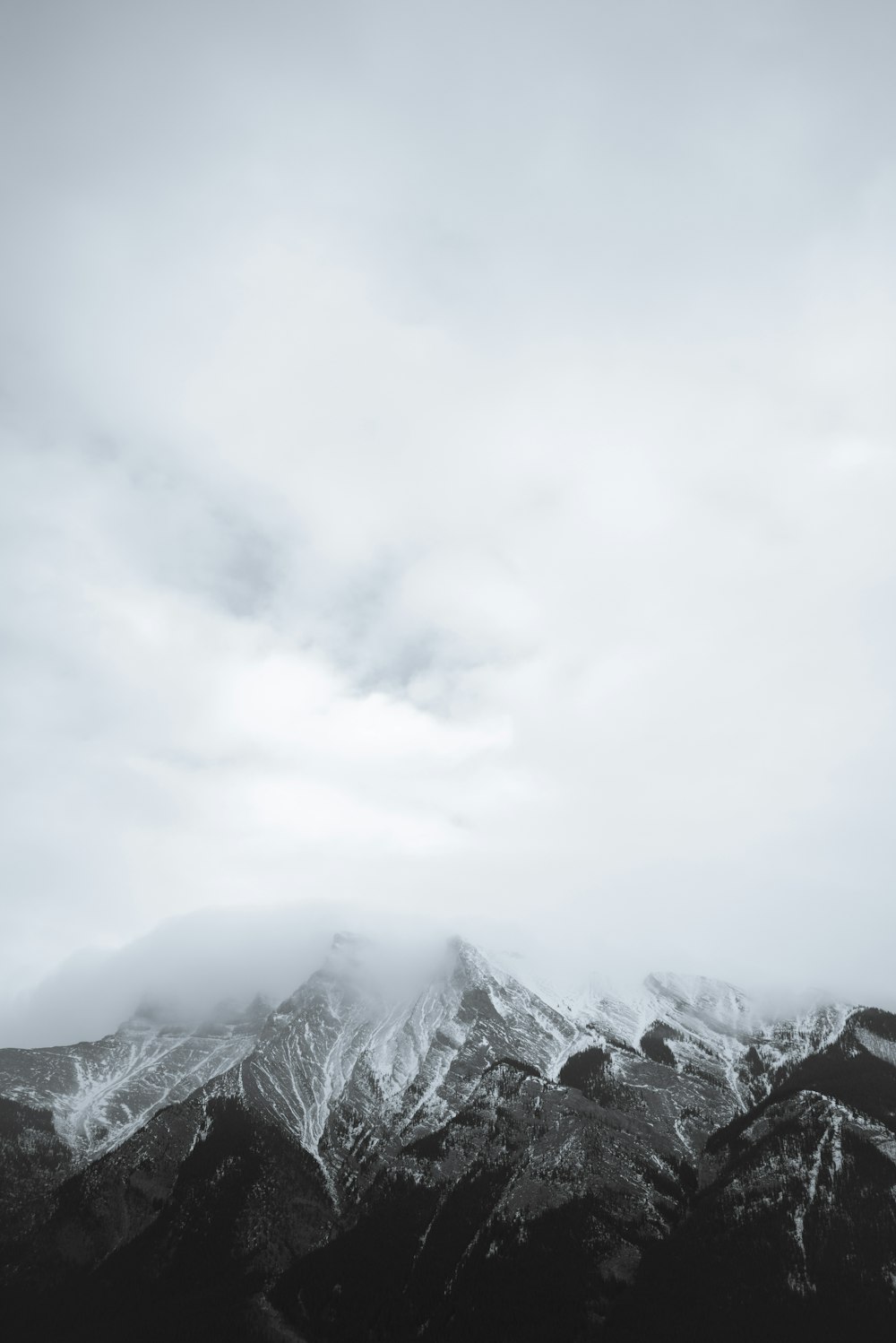 snow covered mountain under cloudy sky during daytime