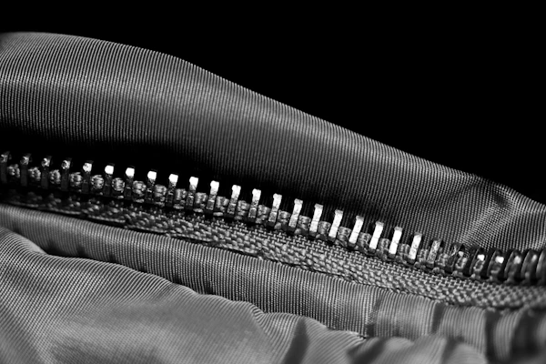 A close view of black and white striped fabric showing the weave and the stitching along a seam.