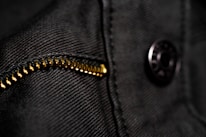 Close-up of modern men's clothing details like zippers and fabric textures in natural light.