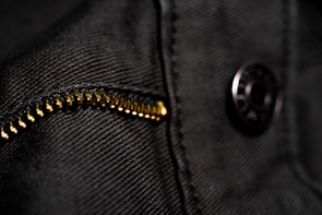 Close-up of detailed stitching and fabric texture on a Lumina Apparel hoodie under soft natural light.