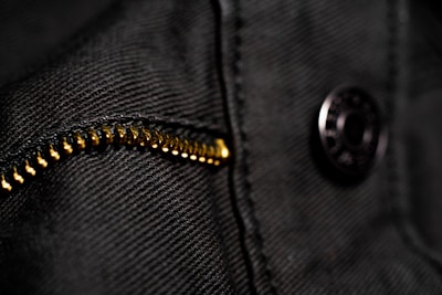 Close-up of modern men's clothing details like zippers and fabric textures in natural light.