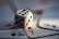 A blurred close-up image of a white dice with black dots surrounded by playing cards displaying the ace of hearts and ace of spades.