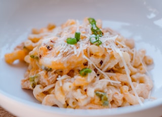 pasta with green leaf on white ceramic plate