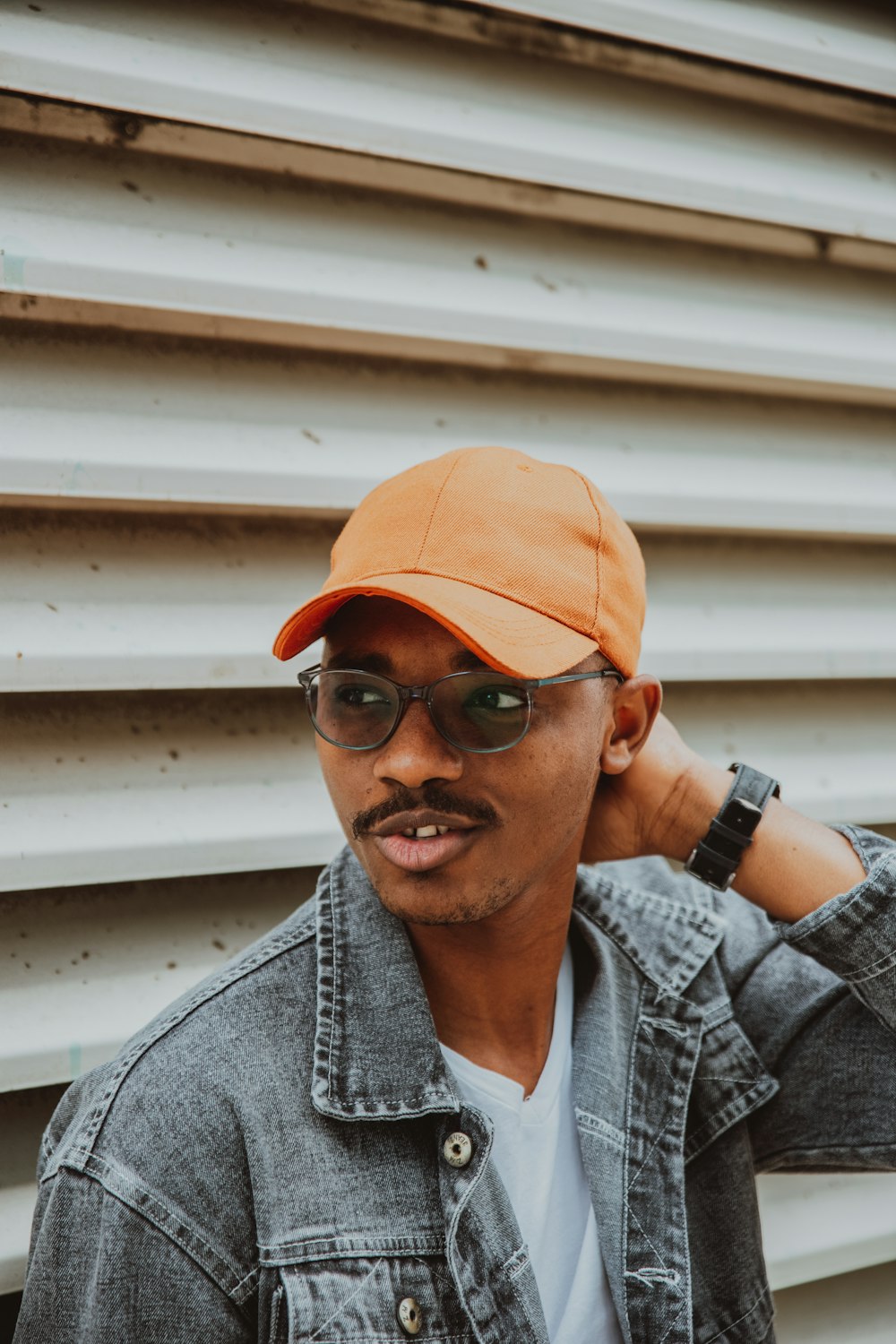 man in gray and white plaid button up shirt wearing orange cap