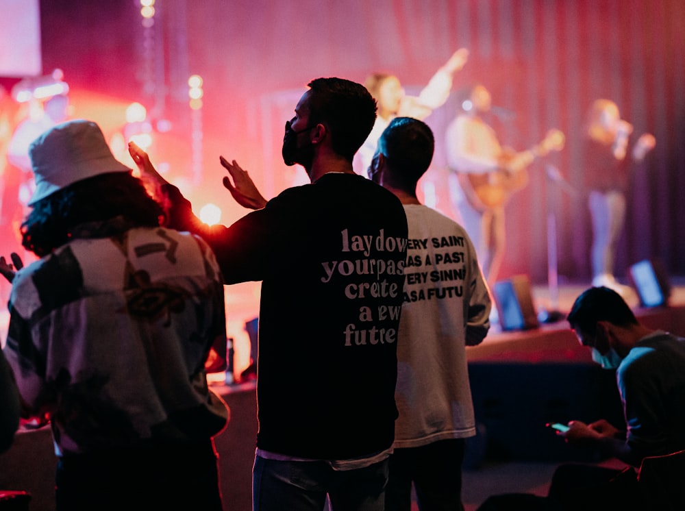 man in gray shirt raising his hands