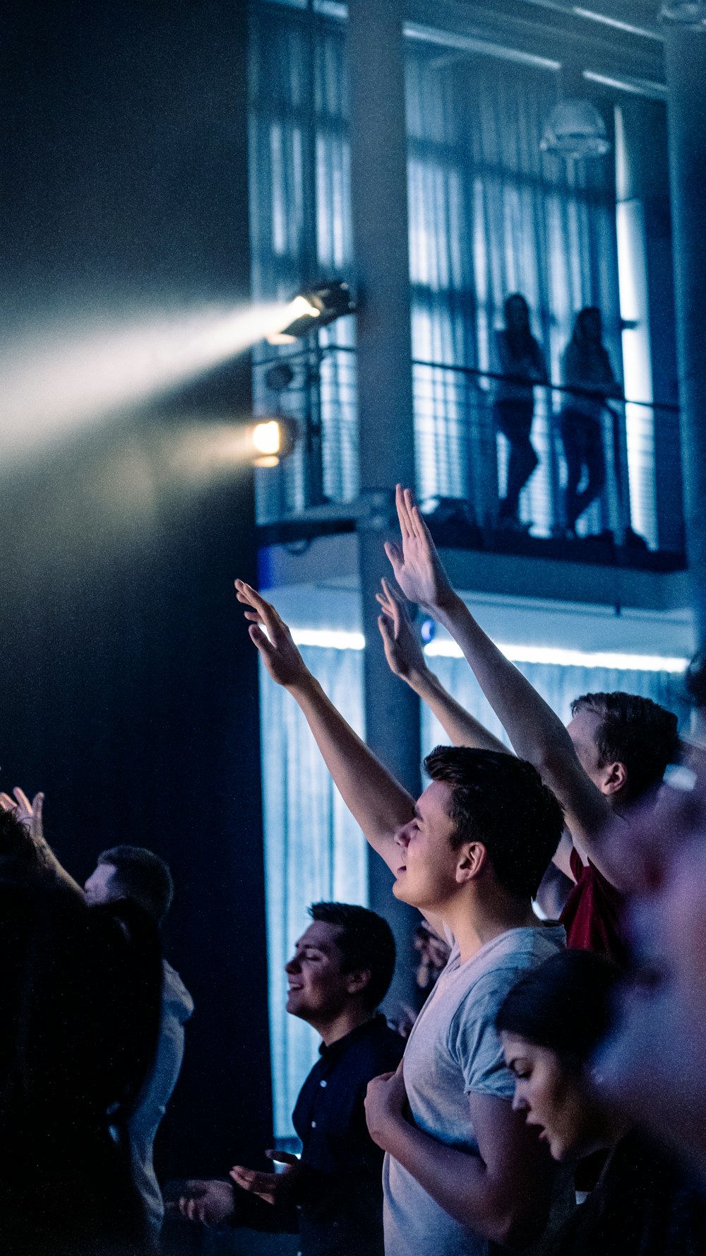 man in white shirt raising his hands