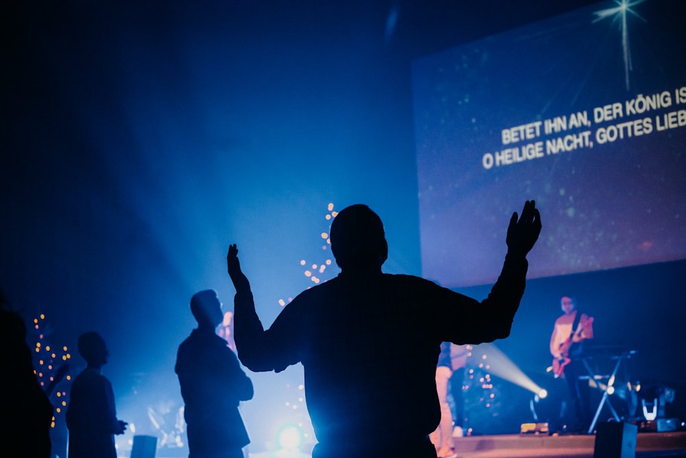 man in black long sleeve shirt raising his hands