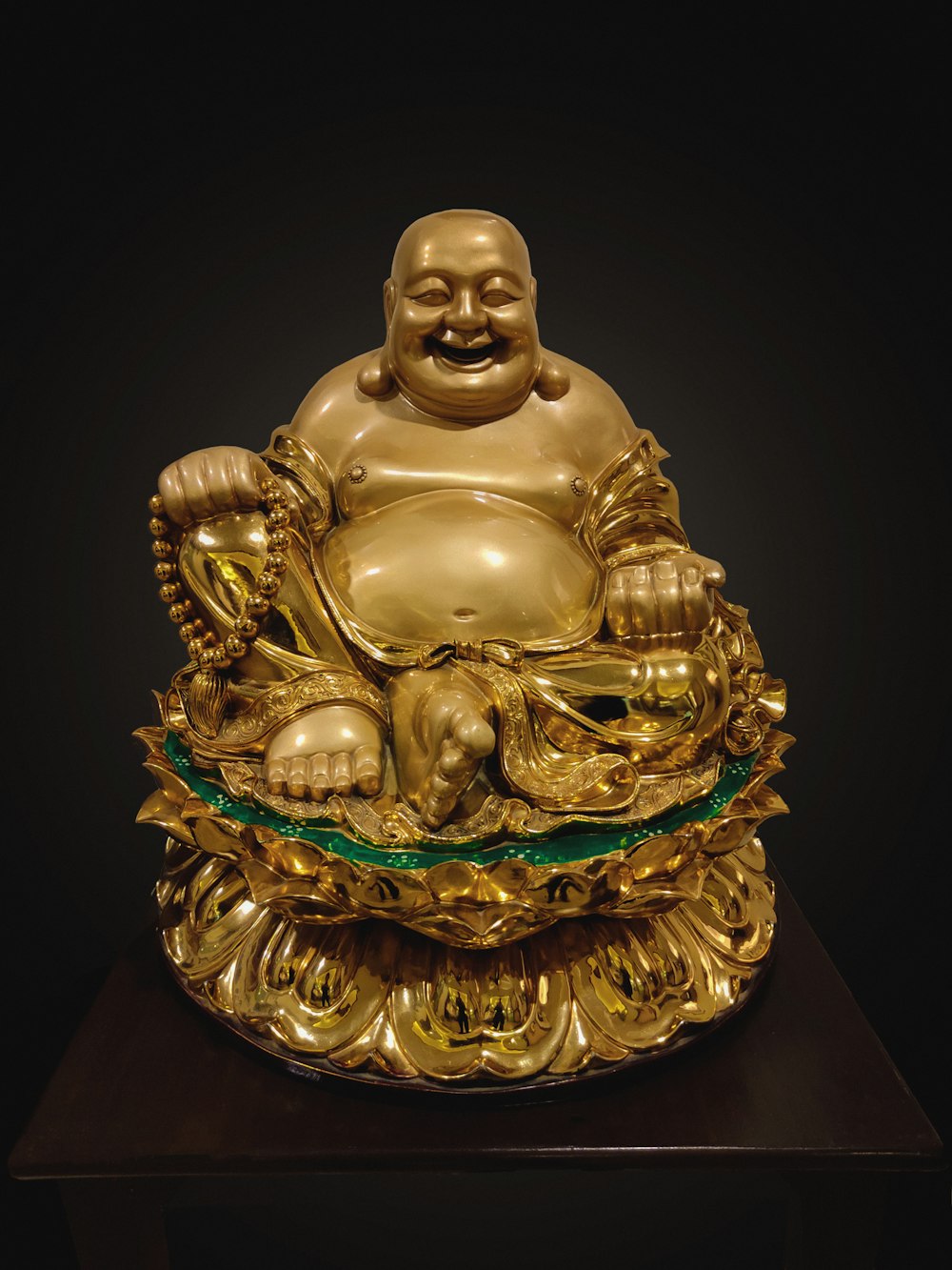 gold buddha figurine on black surface