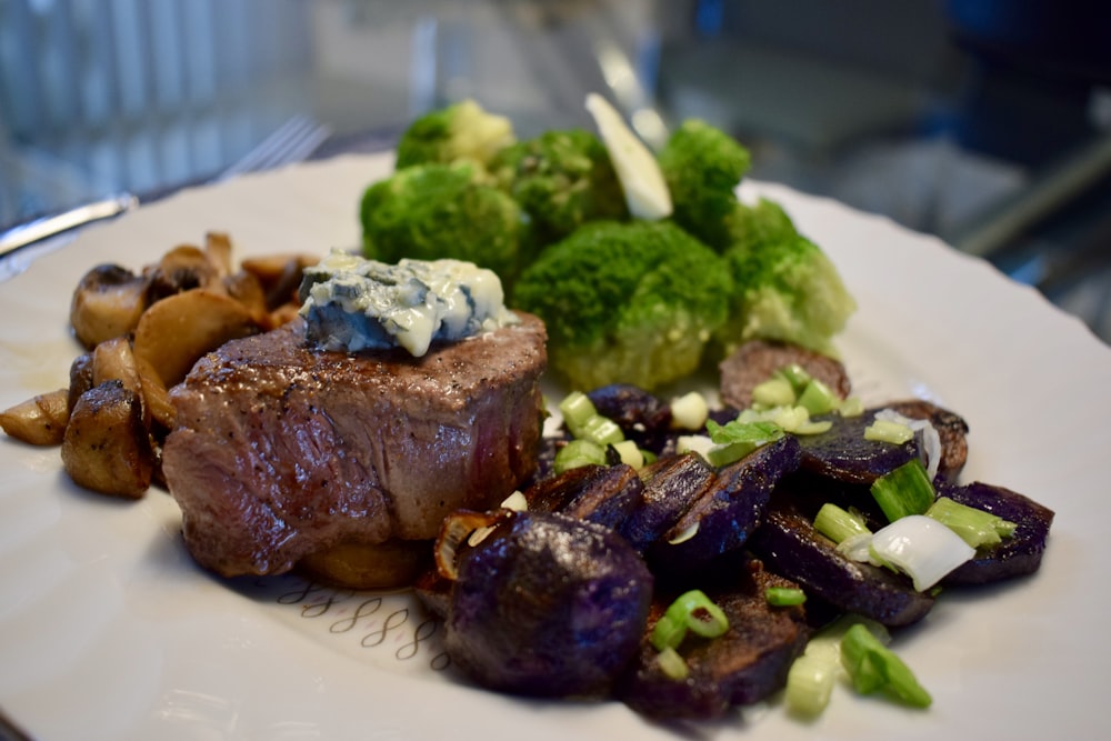 cooked meat with broccoli on white ceramic plate