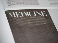 A close-up view of a page with the word 'MEDICINE' prominently displayed in large, bold, white letters on a dark background. Below it, there is smaller, less legible text that appears to be descriptive or informative in nature. The page is part of a larger document or publication.