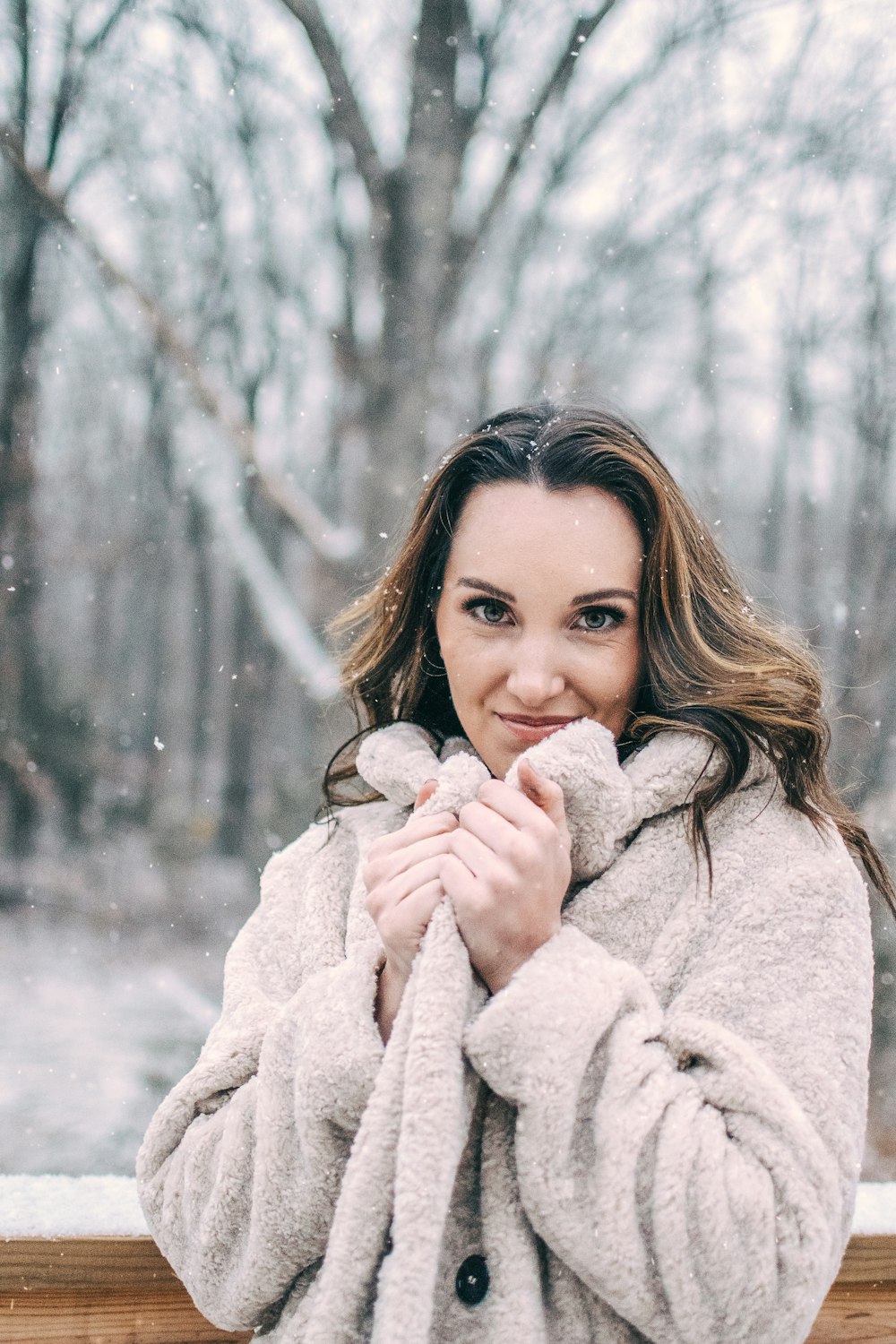 woman in white coat holding snow