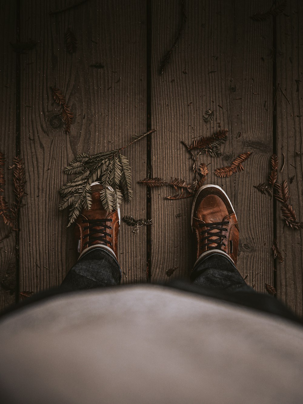 person in black pants and brown leather shoes