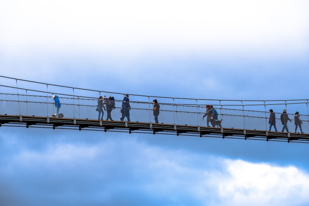 people walking on bridge under white sky during daytime