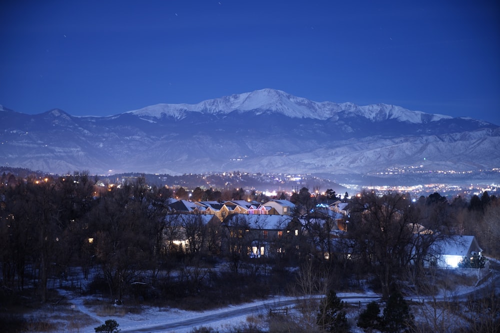 Maisons brunes et blanches près d’une montagne enneigée pendant la journée