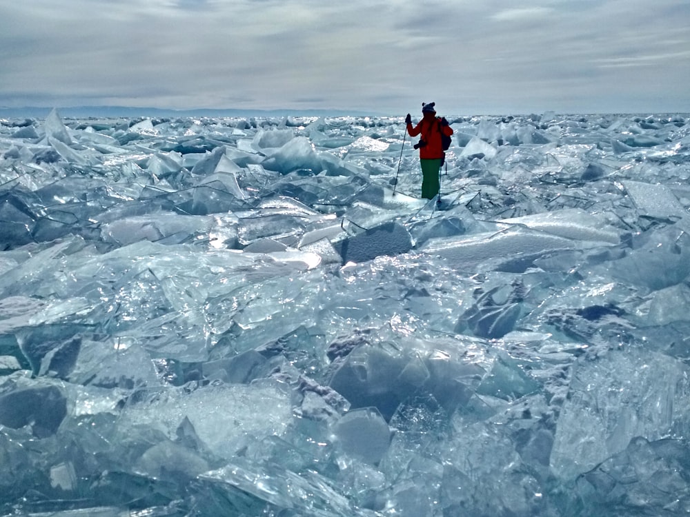 man in black jacket standing on ice covered field during daytime