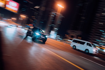 A cinematic still from a music video showing dynamic movement against an urban night backdrop.