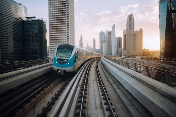 A sleek modern train gliding through a vibrant cityscape at dusk, symbolizing advanced urban rail connectivity.