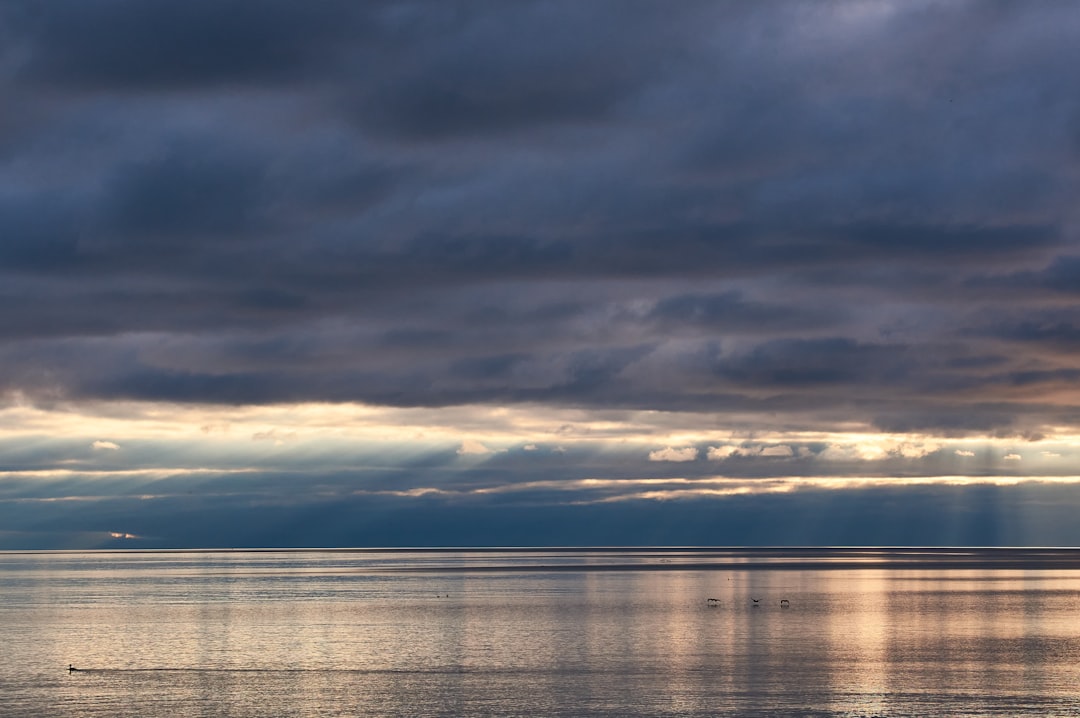 body of water under cloudy sky during daytime