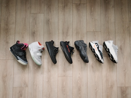 Close-up of a vibrant sneaker collection arranged on a wooden floor, highlighting urban style.