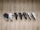 A collection of seven different sneakers lined up on a wooden floor, showcasing a variety of designs and colors.