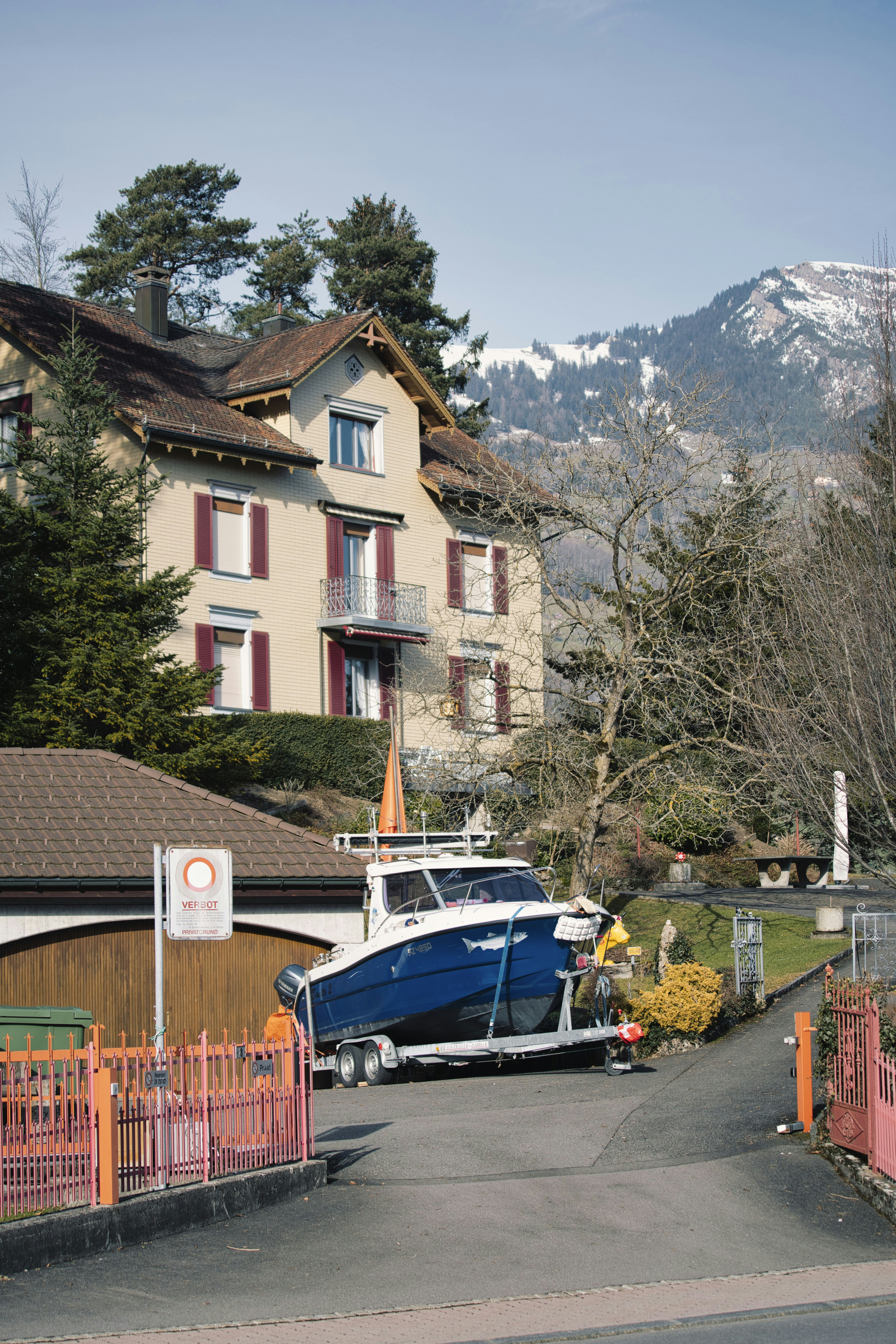 blue and white boat on dock near brown concrete building during daytime