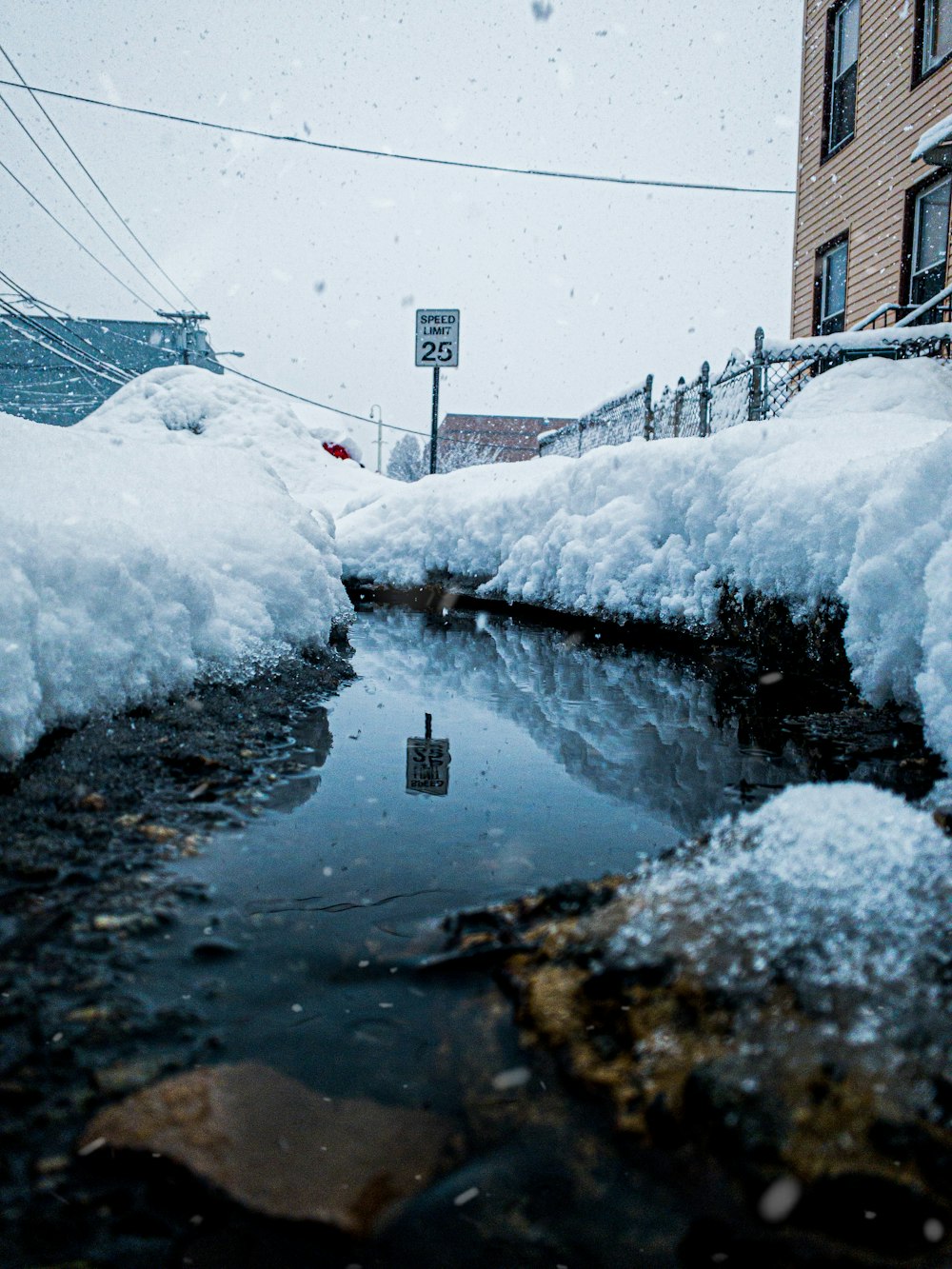 snow covered road near brown building during daytime