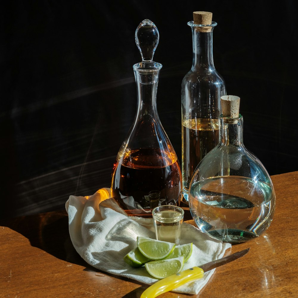 botellas de vidrio transparente sobre una mesa de madera marrón