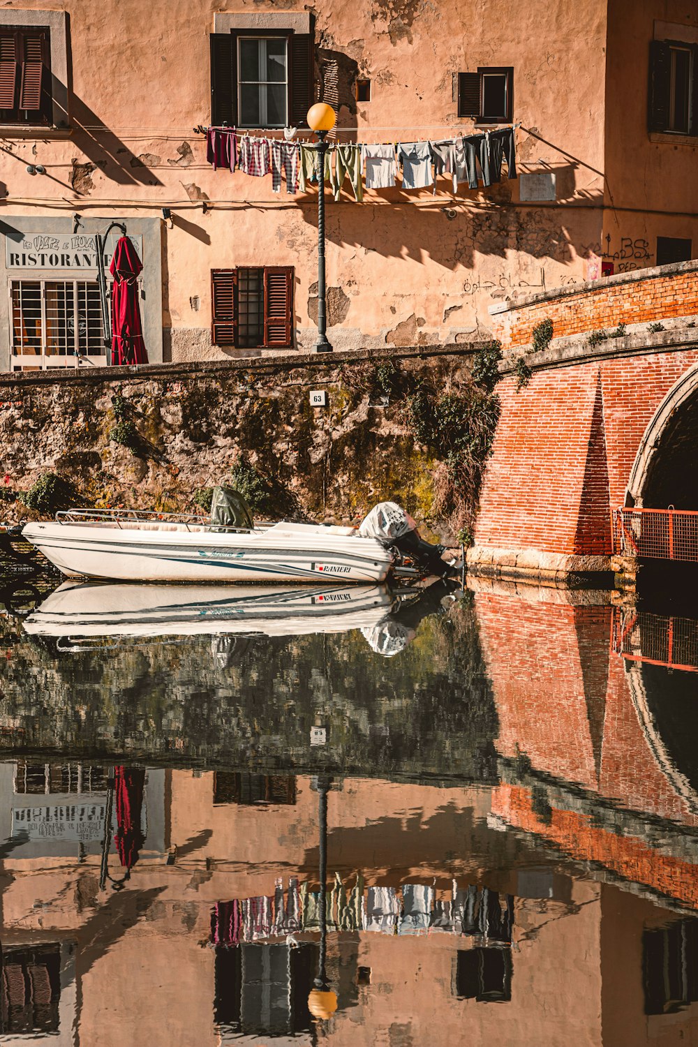 white boat on water near brown concrete building during daytime