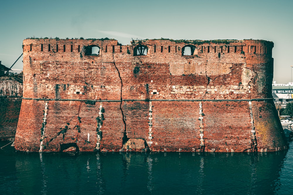 brown concrete building near body of water during daytime