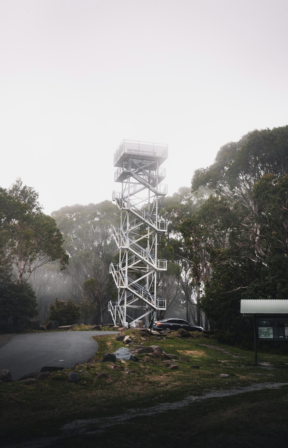 white and black metal tower near green trees during daytime