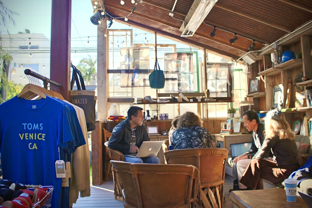 people sitting on brown wooden chairs inside restaurant during daytime