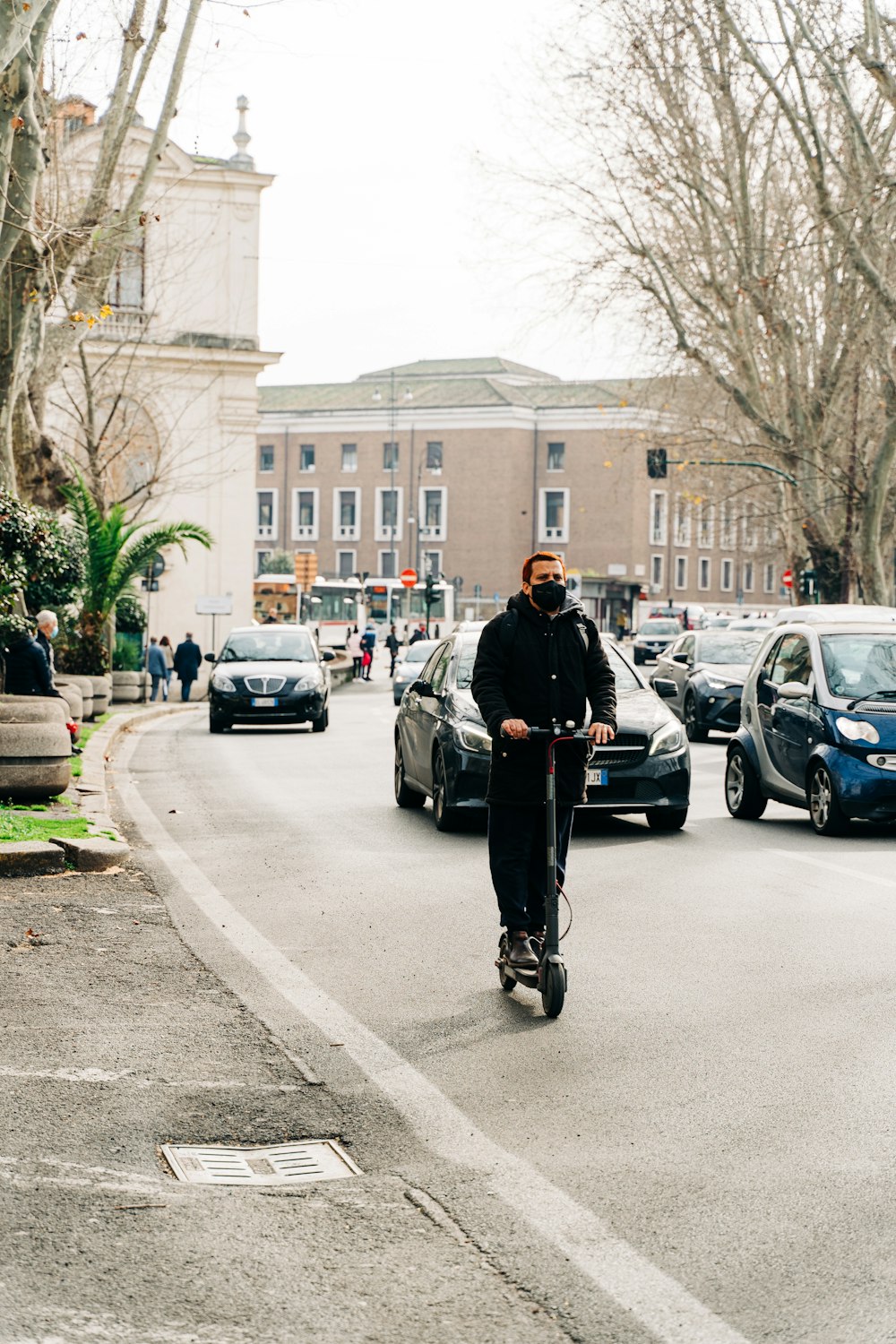 man in black jacket and black pants walking on sidewalk during daytime