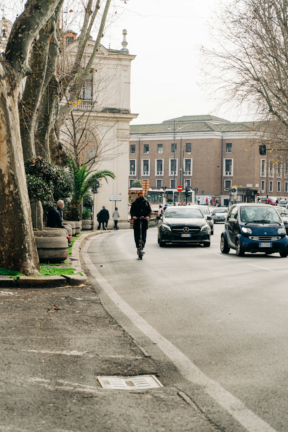 Hombre en chaqueta negra caminando en la acera durante el día