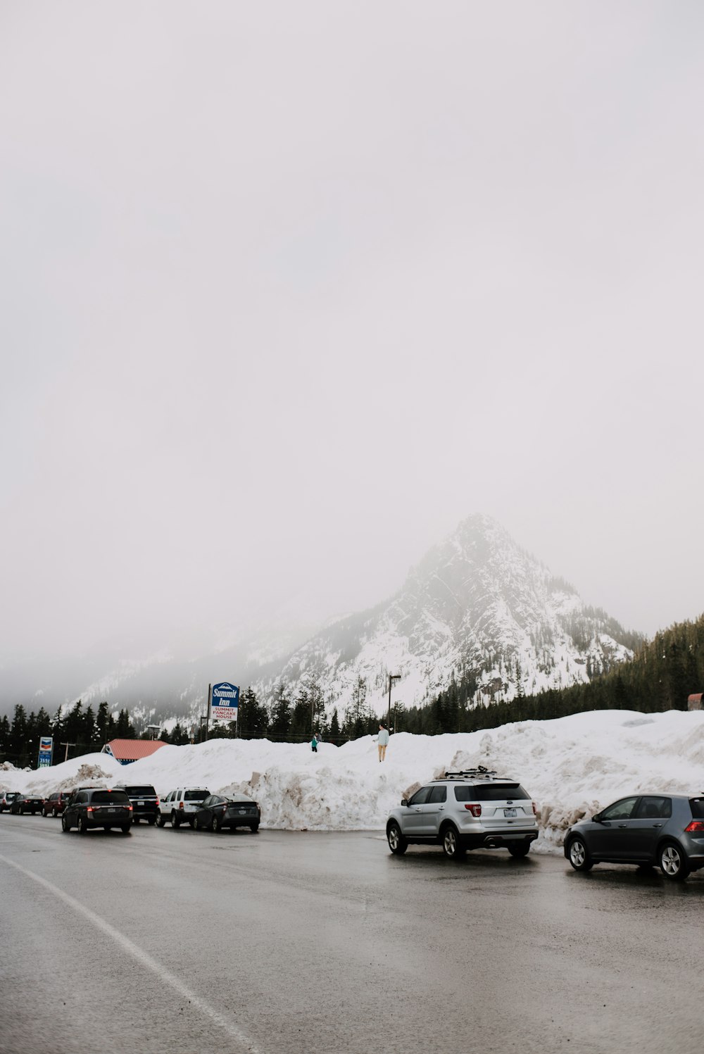 Voitures sur la route près d’une montagne enneigée pendant la journée