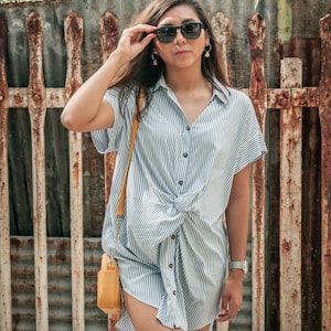 woman in white and blue stripe button up shirt wearing black sunglasses