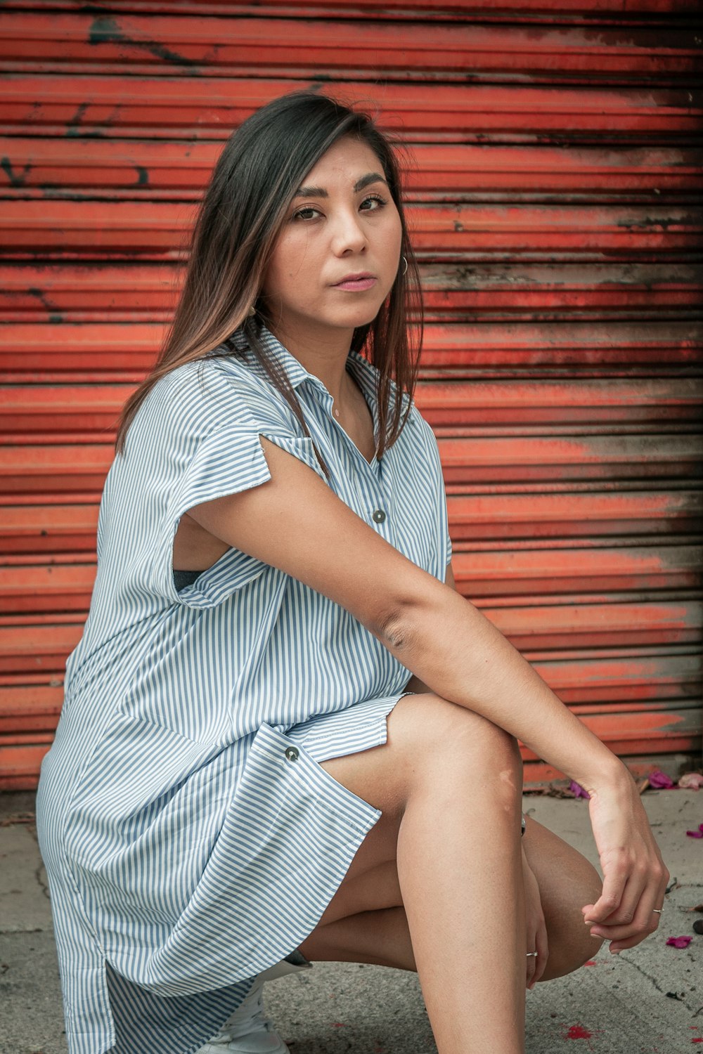 woman in white and black stripe dress sitting on brown wooden floor