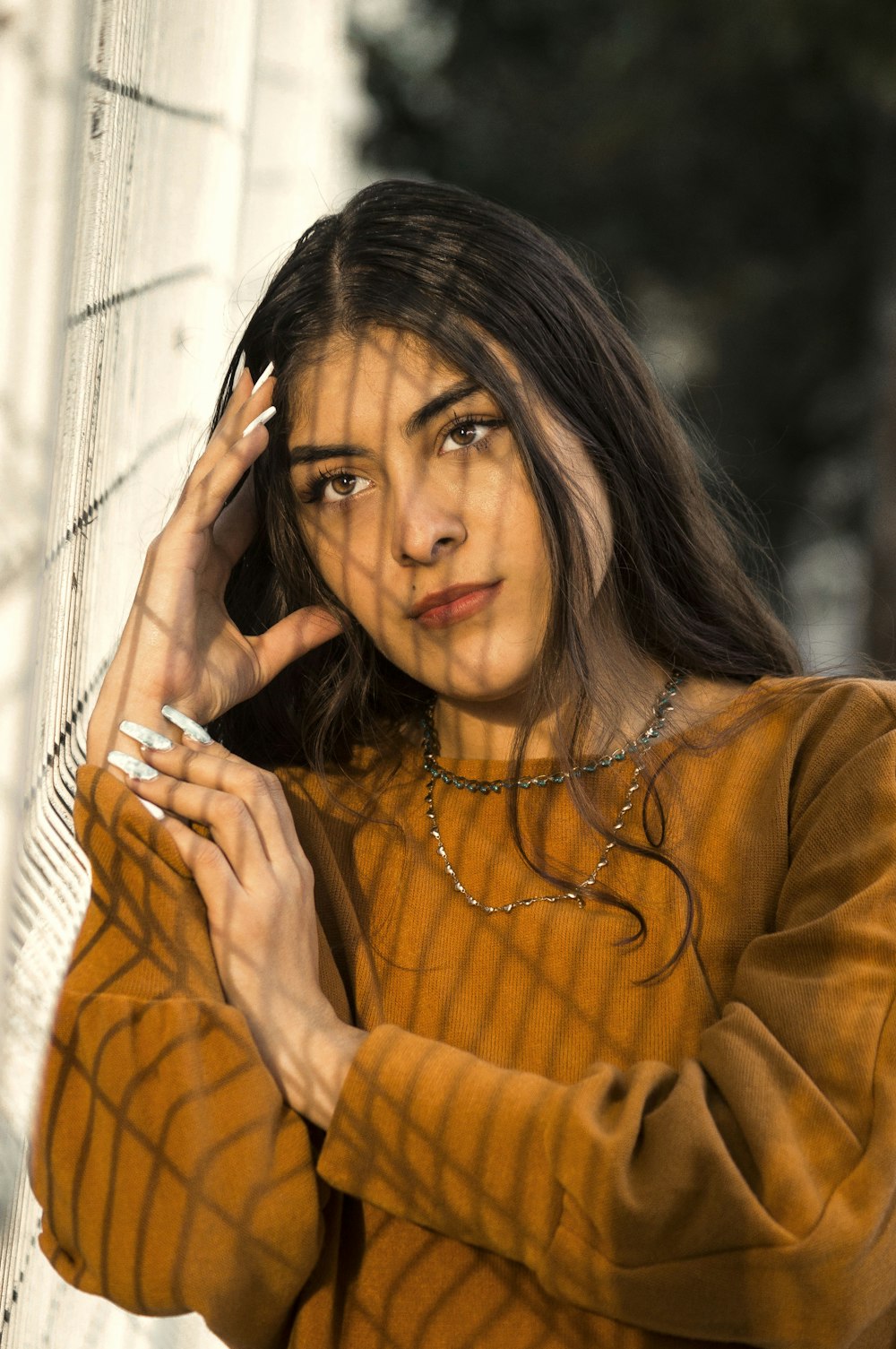 woman in brown sweater holding her hair