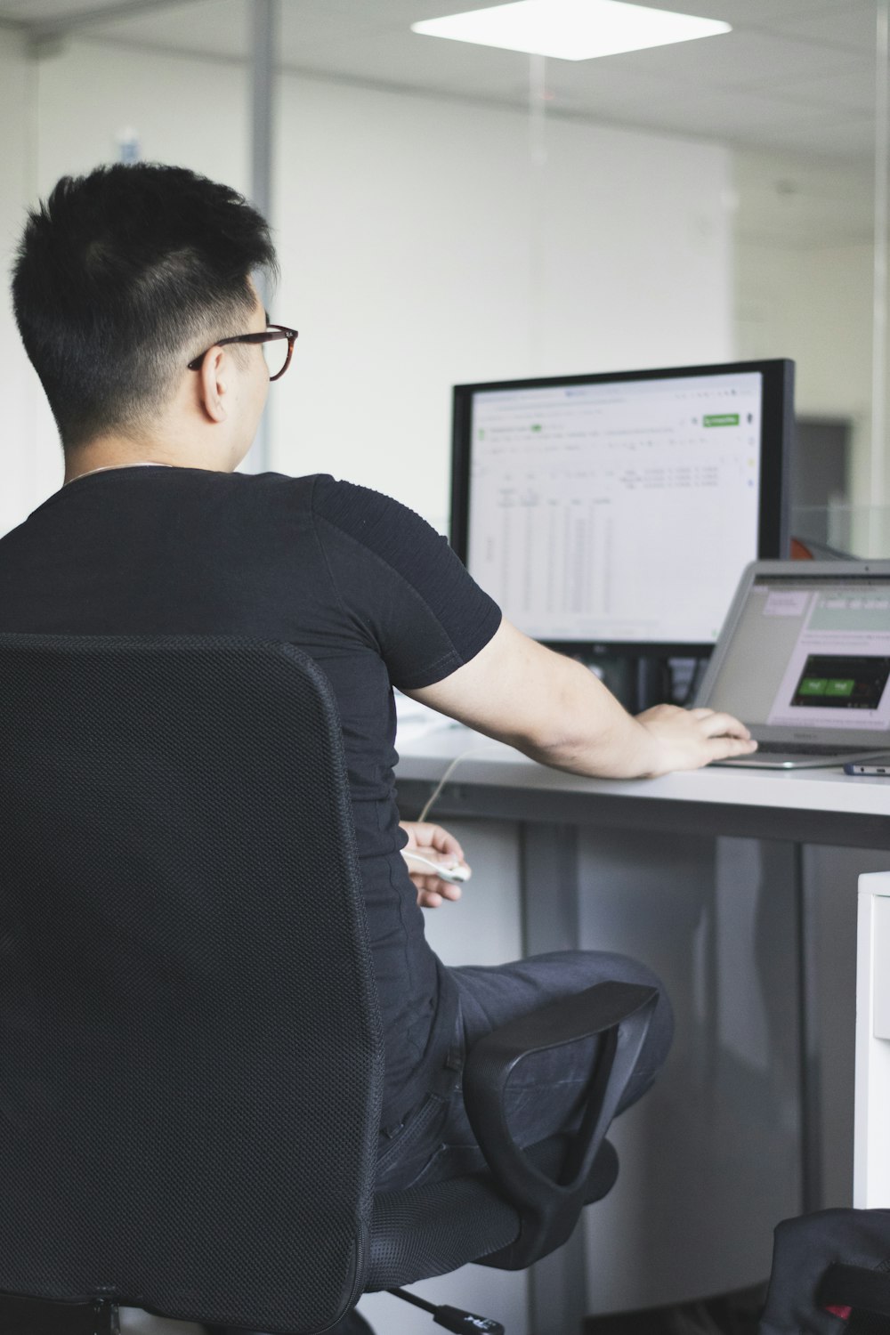 man in black t-shirt using laptop computer