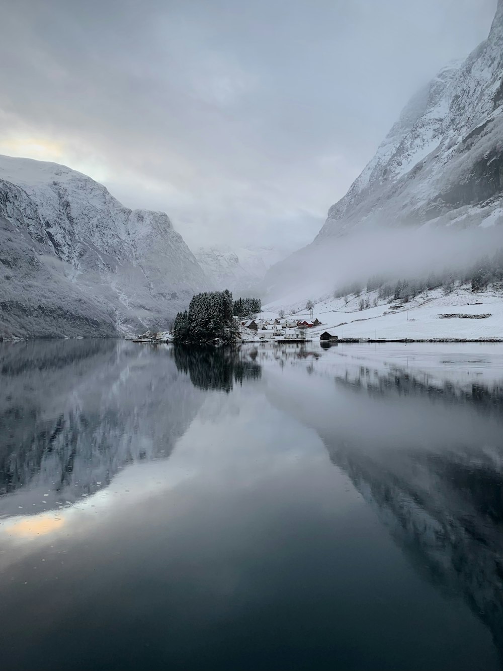 a body of water surrounded by snow covered mountains