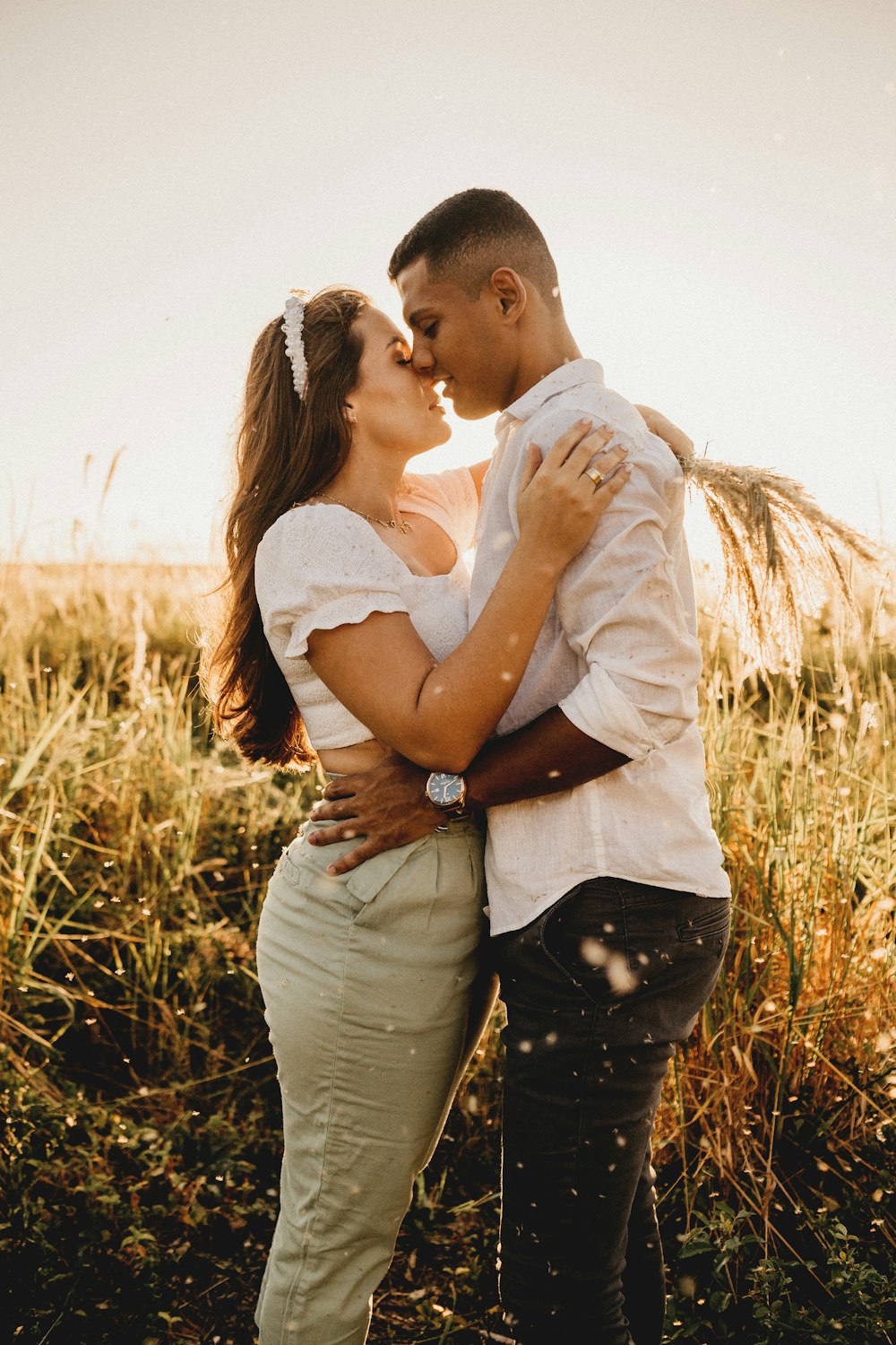man kissing womans forehead on brown grass field during daytime