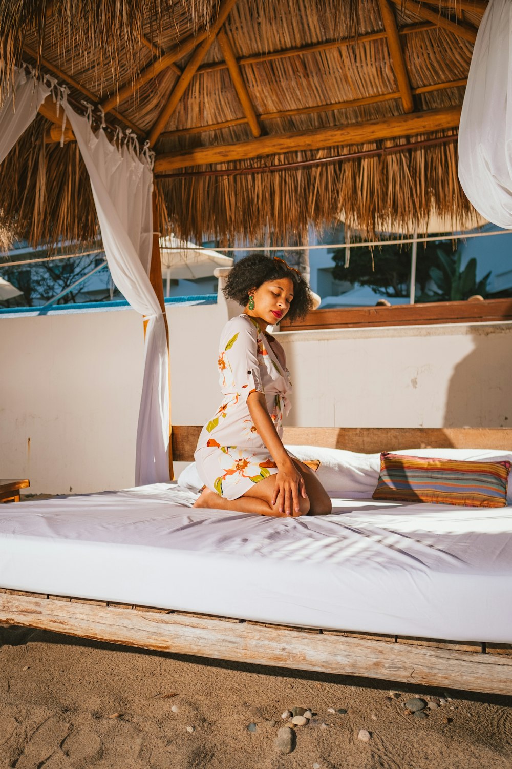 woman in yellow and white floral dress sitting on bed