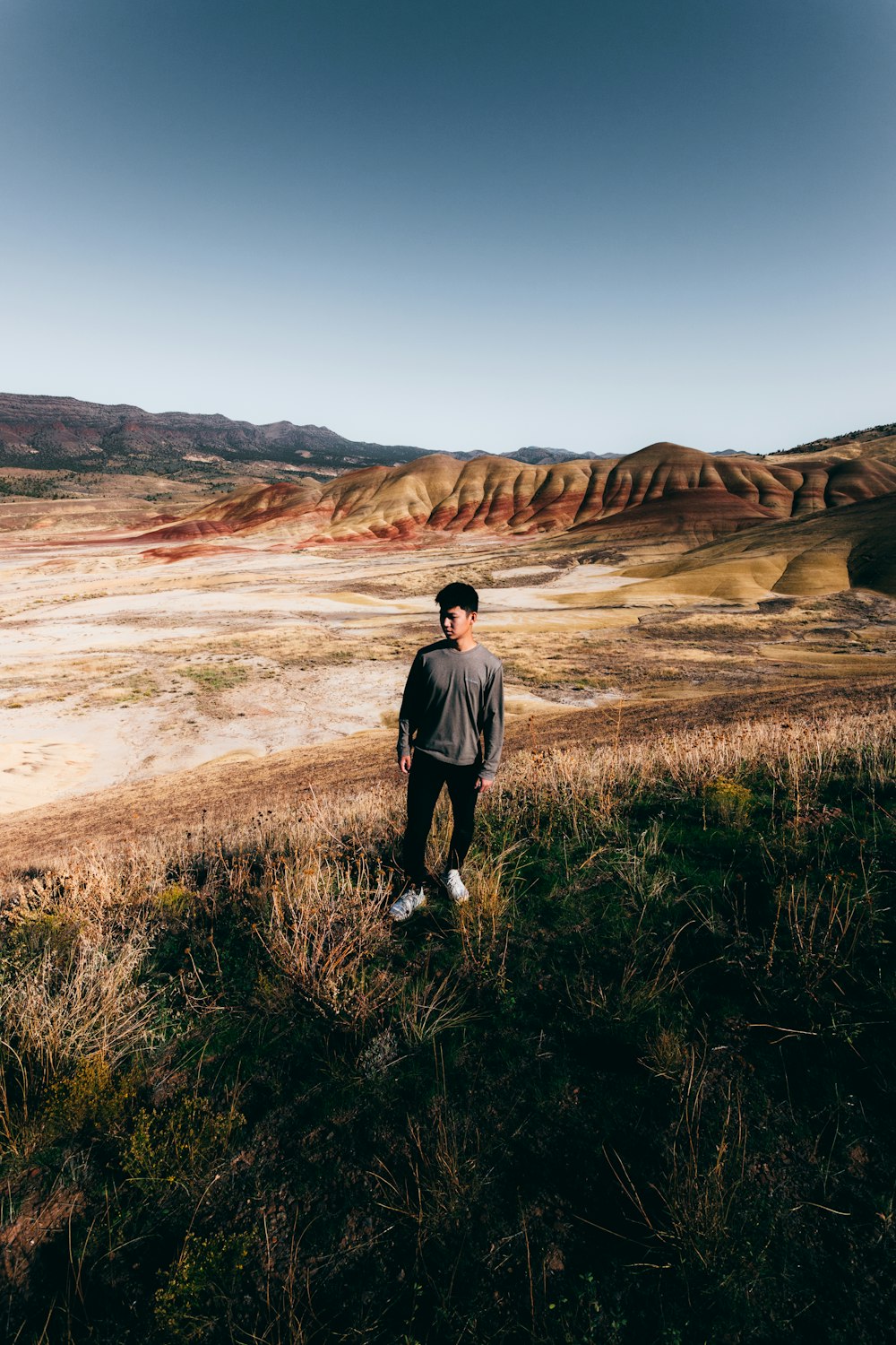 man in black t-shirt standing on green grass field during daytime